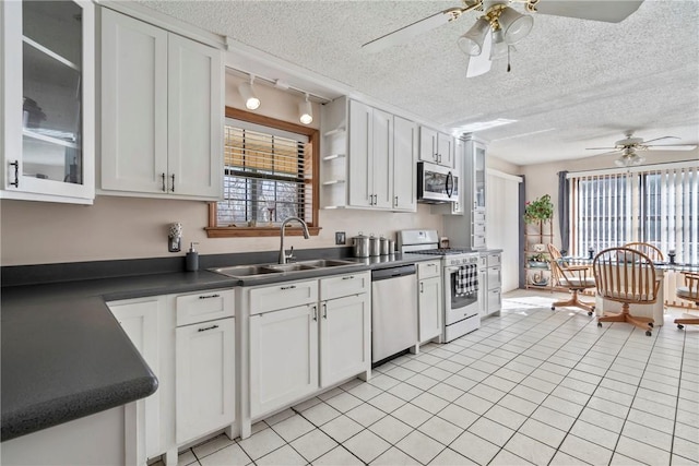 22965 Davis Valley Rd, Gentry, AR 72734 - kitchen featuring dark countertops, a ceiling fan, a sink, and stainless steel appliances