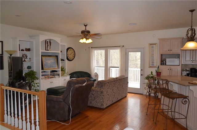 living room with light wood-type flooring and a ceiling fan