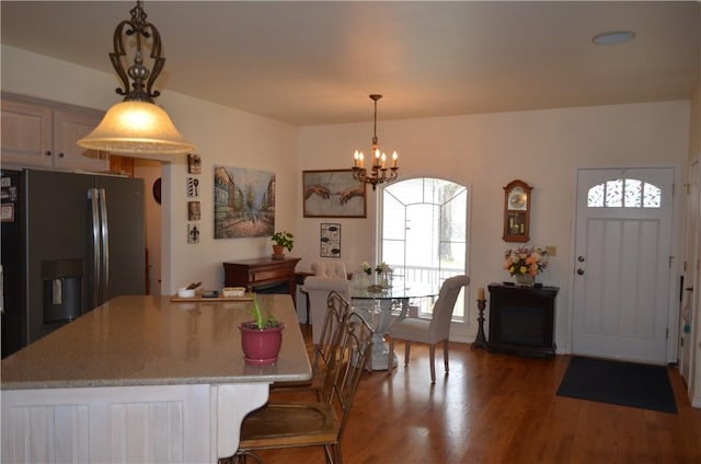 dining room with wood finished floors and a notable chandelier
