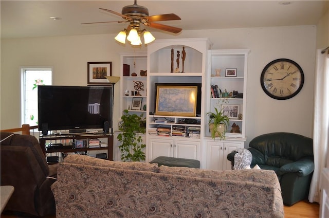 living area with wood finished floors and ceiling fan