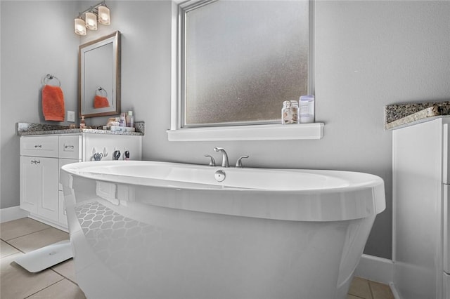 4204 SW Wheatgrass Blvd, Bentonville, AR 72713 - bathroom with tile patterned floors, a freestanding tub, baseboards, and vanity