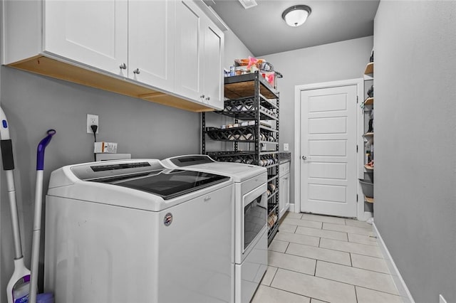 4204 SW Wheatgrass Blvd, Bentonville, AR 72713 - laundry room featuring separate washer and dryer, cabinet space, light tile patterned flooring, and baseboards