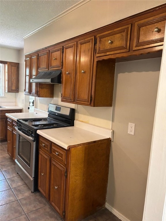 kitchen with stainless steel range with electric cooktop, under cabinet range hood, light countertops, a textured ceiling, and brown cabinets