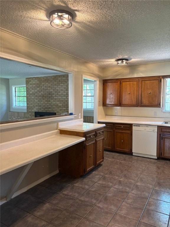 kitchen featuring dishwasher, a textured ceiling, healthy amount of natural light, light countertops, and a brick fireplace