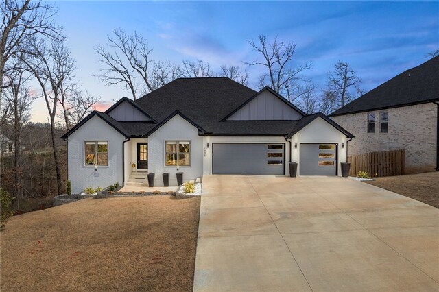 1904 NE Frost Dr, Bentonville, AR 72712 - modern farmhouse style home with driveway, roof with shingles, stucco siding, fence, and an attached garage
