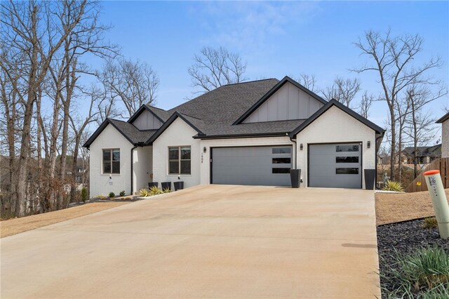 1904 NE Frost Dr, Bentonville, AR 72712 - view of front of property with board and batten siding, driveway, a shingled roof, and an attached garage