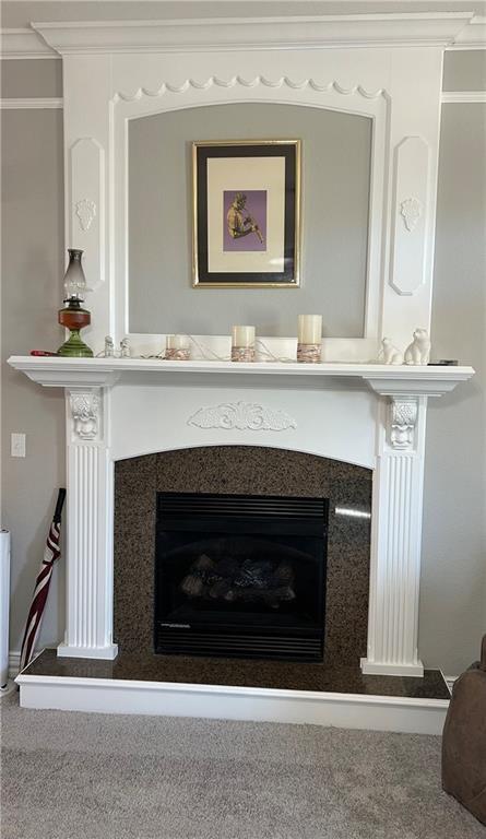 room details with a fireplace, crown molding, and carpet floors