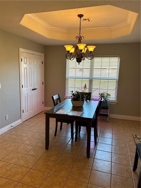 dining room featuring a notable chandelier, crown molding, light tile patterned floors, and a raised ceiling