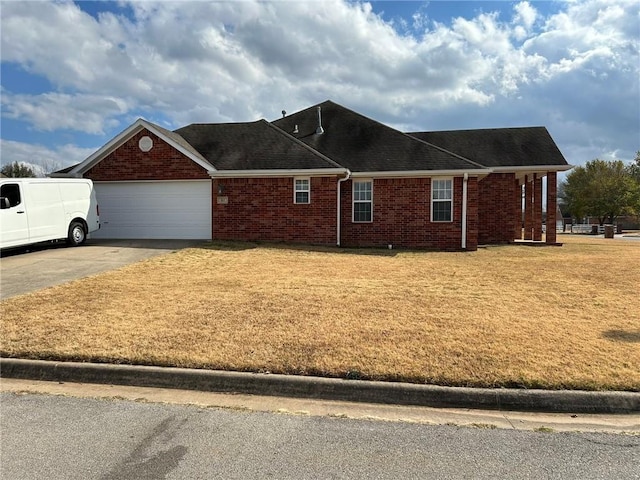 view of front of house with driveway, brick siding, a front lawn, and an attached garage