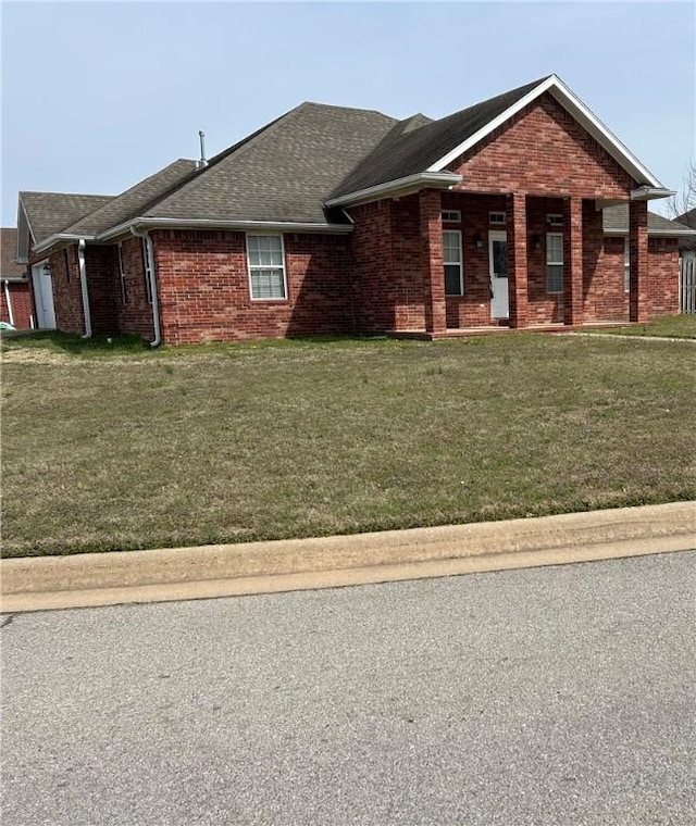 single story home with a front lawn, a garage, and brick siding