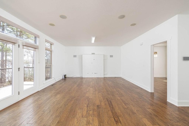 spare room with wood finished floors and a healthy amount of sunlight
