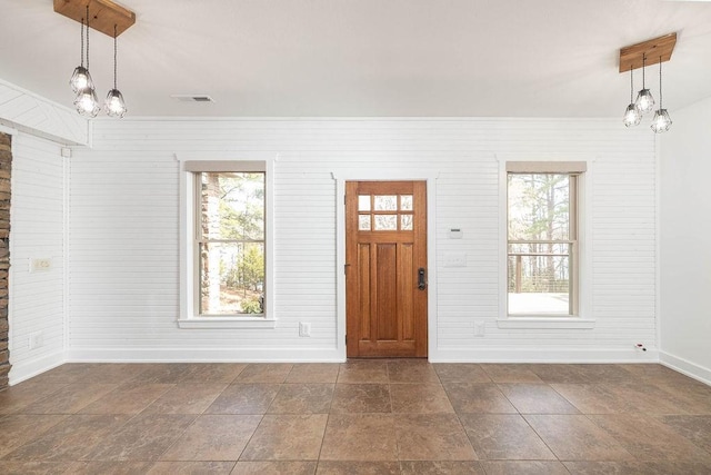foyer featuring baseboards, plenty of natural light, visible vents, and an inviting chandelier