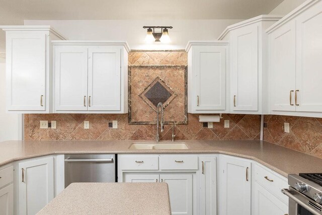 kitchen featuring light countertops, a sink, white cabinets, and stainless steel appliances