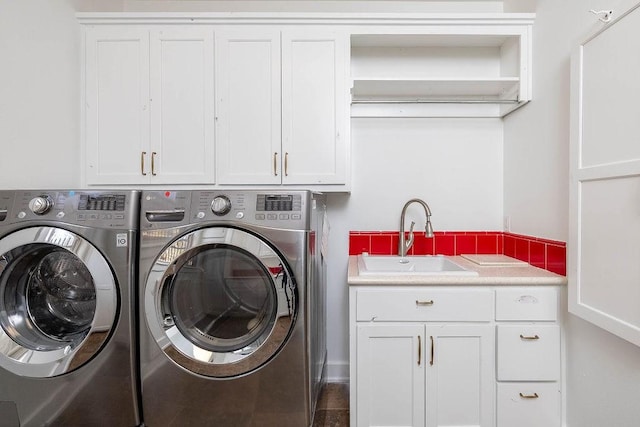 laundry room featuring cabinet space, independent washer and dryer, and a sink