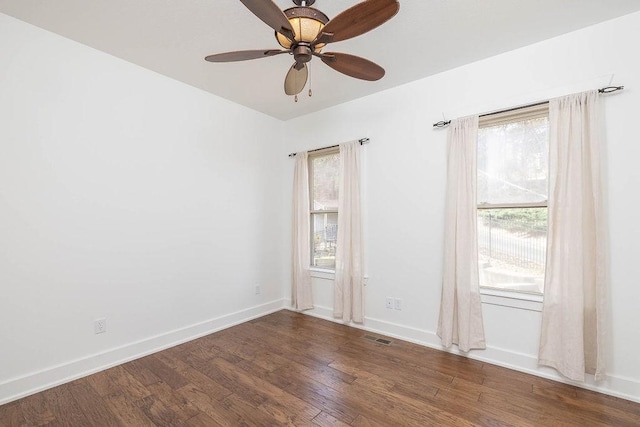 unfurnished room with a ceiling fan, baseboards, visible vents, and wood finished floors