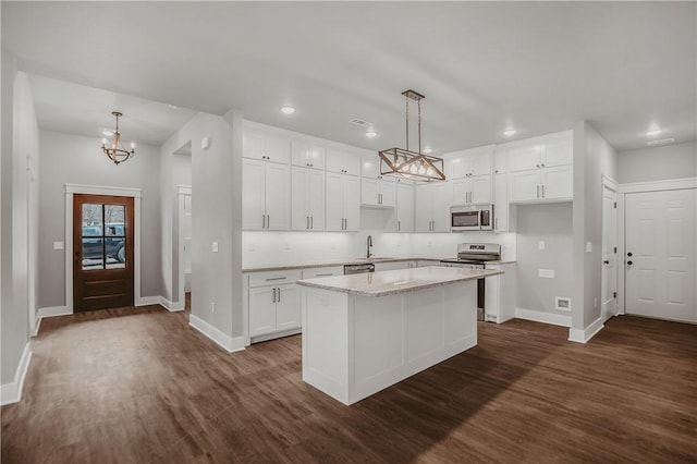 9 Beaty Ln, Bella Vista, AR 72715 - kitchen featuring an inviting chandelier, dark wood-style floors, a kitchen island, appliances with stainless steel finishes, and a sink