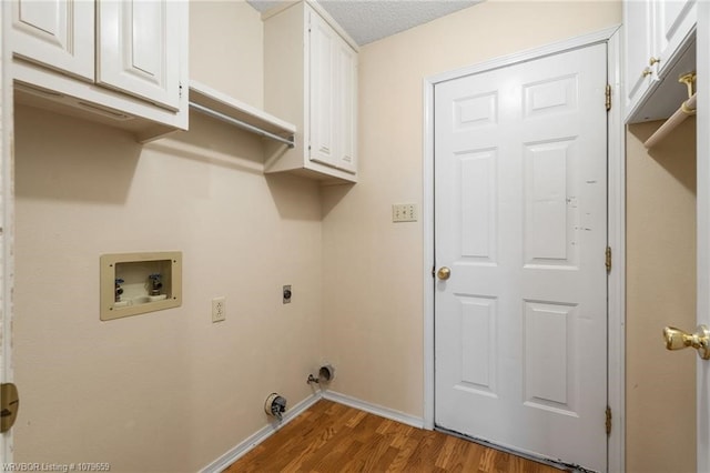 washroom featuring wood finished floors, hookup for an electric dryer, baseboards, cabinet space, and washer hookup