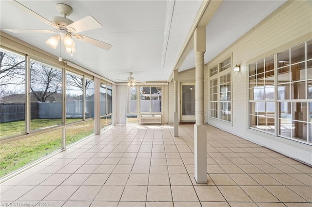 unfurnished sunroom featuring ceiling fan