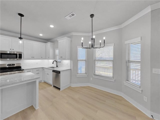 6 Osborne Ln, Bella Vista, AR 72715 - kitchen featuring appliances with stainless steel finishes, a sink, a chandelier, plenty of natural light, and crown molding