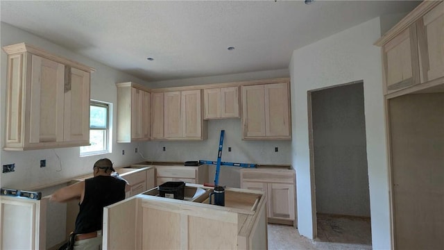 6 Osborne Ln, Bella Vista, AR 72715 - kitchen with light brown cabinetry, a center island, and a textured ceiling