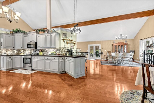 1401 Vickie Cir, Berryville, AR 72616 - kitchen with stainless steel appliances, a chandelier, dark countertops, light wood-type flooring, and high vaulted ceiling