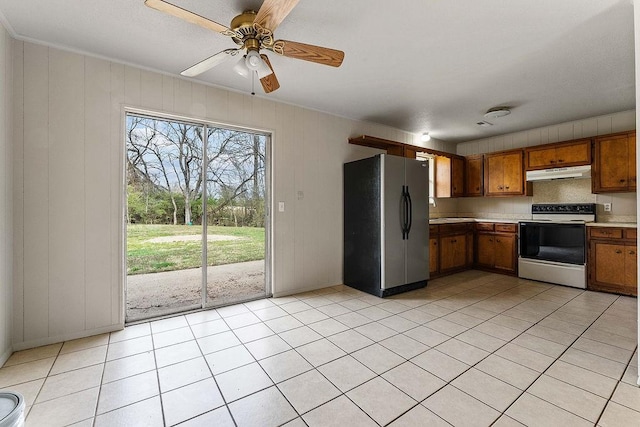 5694/925668/665644/42 W Michael Cole Dr, Fayetteville, AR 72704 - kitchen featuring light countertops, freestanding refrigerator, brown cabinetry, under cabinet range hood, and range with electric cooktop