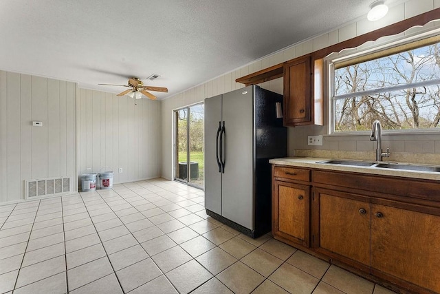 5694/925668/665644/42 W Michael Cole Dr, Fayetteville, AR 72704 - kitchen with visible vents, ceiling fan, a sink, brown cabinetry, and freestanding refrigerator