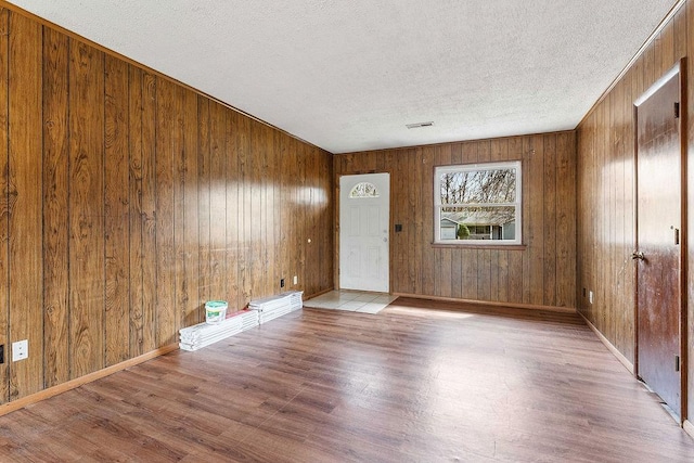 5694/925668/665644/42 W Michael Cole Dr, Fayetteville, AR 72704 - unfurnished room featuring baseboards, a textured ceiling, wood finished floors, and wooden walls