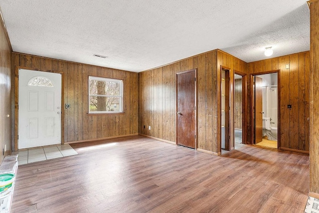 5694/925668/665644/42 W Michael Cole Dr, Fayetteville, AR 72704 - foyer featuring baseboards, a textured ceiling, wood finished floors, and wooden walls