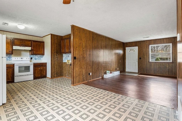 5694/925668/665644/42 W Michael Cole Dr, Fayetteville, AR 72704 - kitchen with under cabinet range hood, light countertops, wood walls, and white appliances