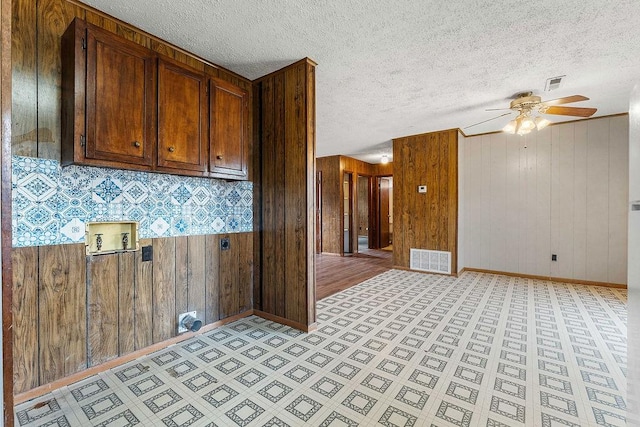 5694/925668/665644/42 W Michael Cole Dr, Fayetteville, AR 72704 - kitchen featuring baseboards, a textured ceiling, wooden walls, ceiling fan, and visible vents