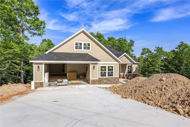 7 Boreray Ln, Bella Vista, AR 72715 - view of front facade with stone siding, a garage, a porch, and a shingled roof