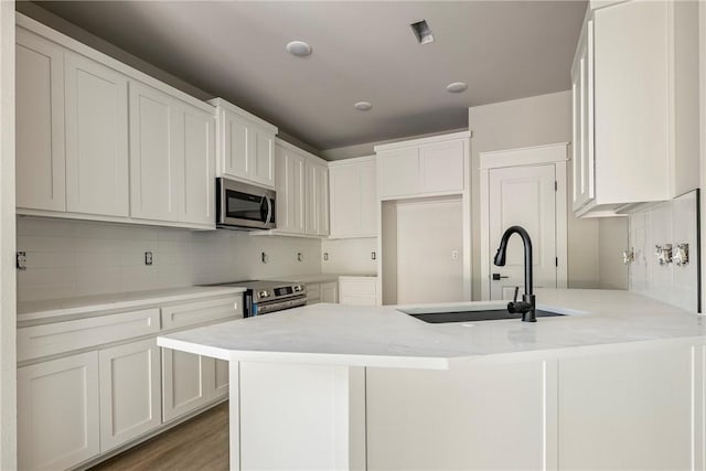 7 Boreray Ln, Bella Vista, AR 72715 - kitchen with appliances with stainless steel finishes, a sink, decorative backsplash, and white cabinets