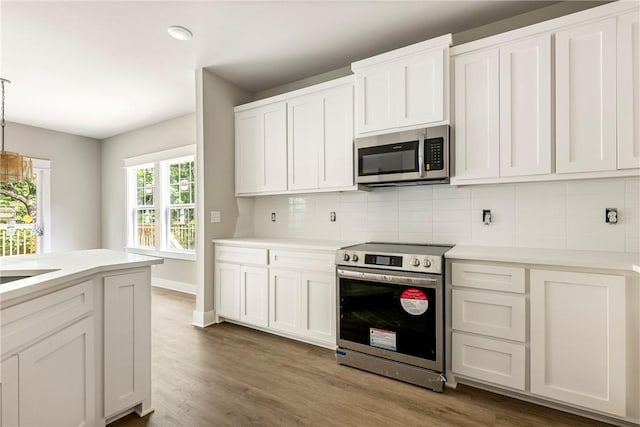 7 Boreray Ln, Bella Vista, AR 72715 - kitchen featuring appliances with stainless steel finishes, tasteful backsplash, light countertops, white cabinetry, and wood finished floors