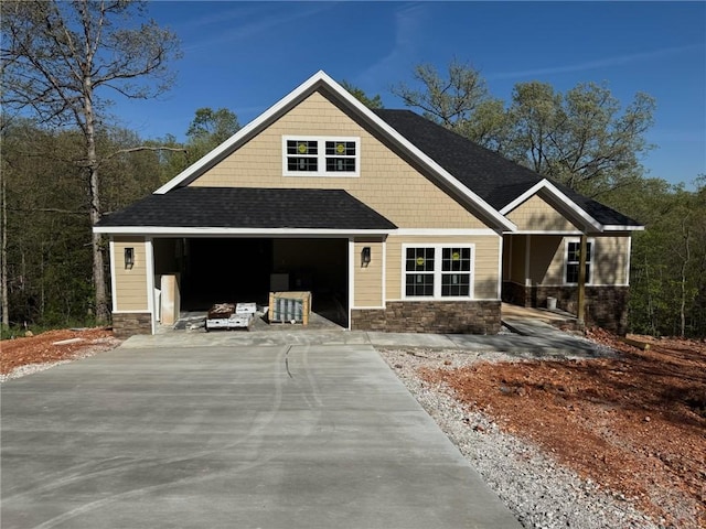 7 Boreray Ln, Bella Vista, AR 72715 - craftsman-style house with a garage, stone siding, driveway, roof with shingles, and a porch