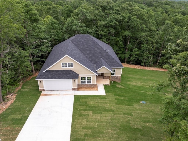 7 Boreray Ln, Bella Vista, AR 72715 - view of front of home with a view of trees, concrete driveway, a garage, a shingled roof, and a front lawn