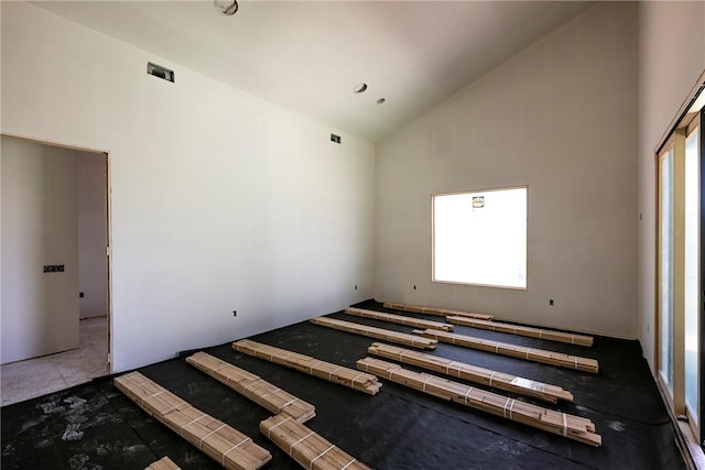 unfurnished bedroom featuring high vaulted ceiling and multiple windows