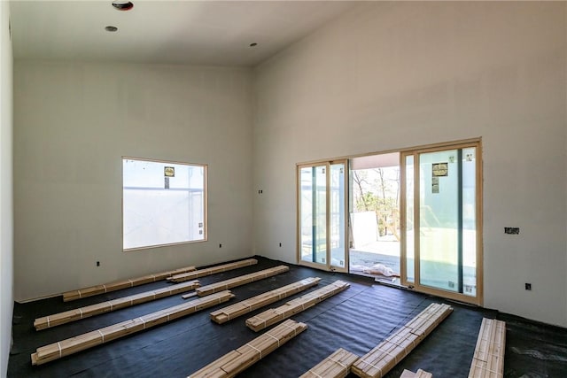 empty room featuring plenty of natural light and a towering ceiling