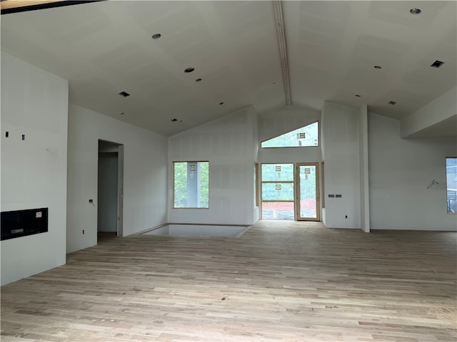 unfurnished room with light wood-type flooring, beam ceiling, visible vents, and high vaulted ceiling