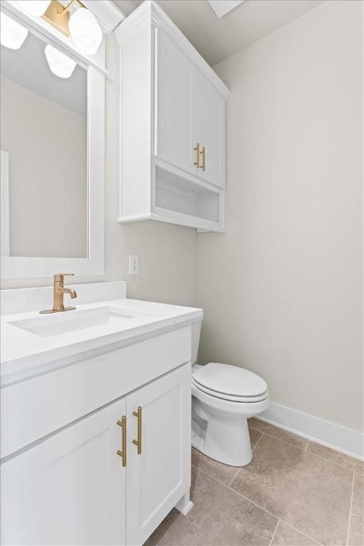 half bath featuring toilet, vanity, tile patterned floors, and baseboards