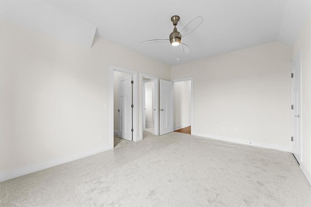 carpeted empty room featuring baseboards and a ceiling fan