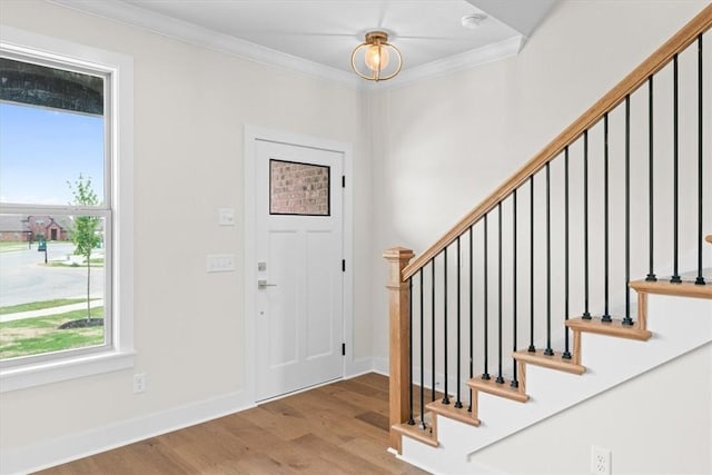 foyer with stairway, ornamental molding, and wood finished floors