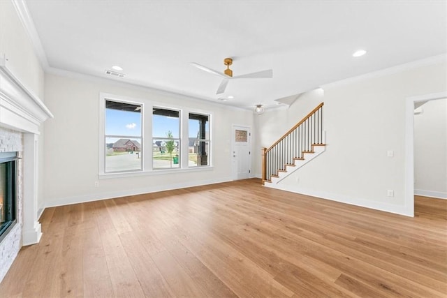 unfurnished living room featuring visible vents, a fireplace, stairs, and ornamental molding