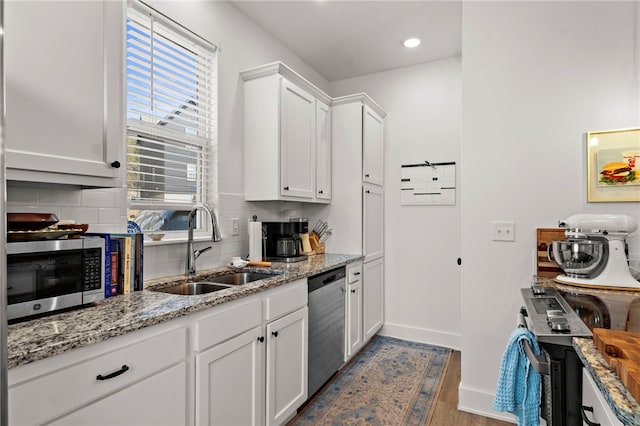 845 One Mile Rd, Fayetteville, AR 72704 - kitchen featuring appliances with stainless steel finishes, a sink, backsplash, white cabinets, and light stone countertops