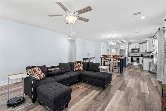 living area with visible vents, wood finished floors, recessed lighting, and a ceiling fan