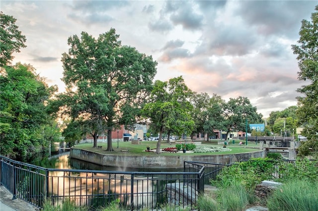 surrounding community featuring a water view and fence