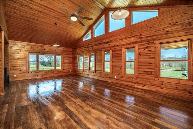 unfurnished living room with wooden walls, a ceiling fan, wood ceiling, and hardwood / wood-style floors
