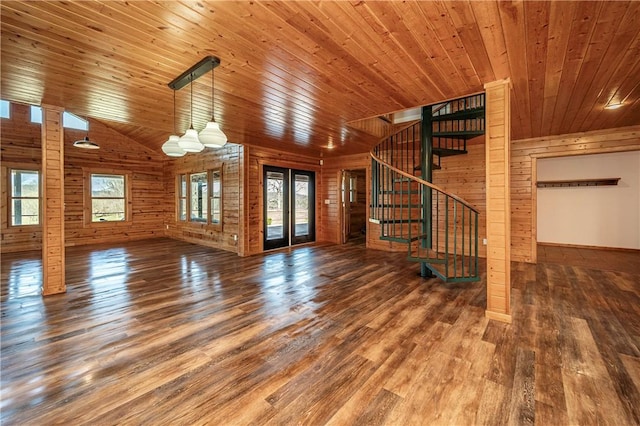 unfurnished living room with wooden ceiling, wooden walls, stairs, and wood finished floors