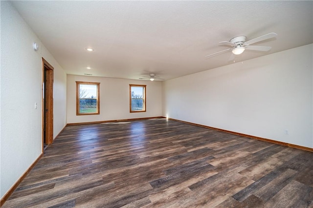 empty room with baseboards, dark wood-style flooring, and a ceiling fan