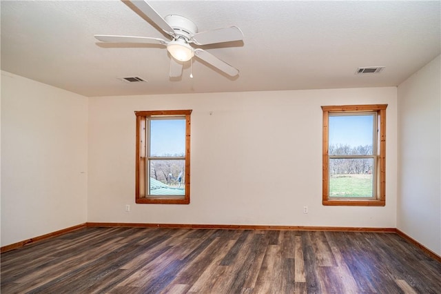 unfurnished room with wood finished floors, baseboards, and visible vents